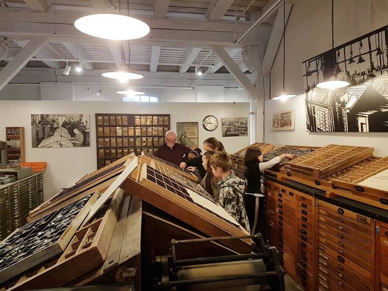Blick in die Setzerei des Druckmuseums mit schräg gestellten Setzkästen.