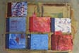 Selbst gestaltete Buntpapiere in Rot und Blau liegen nebeneinander.